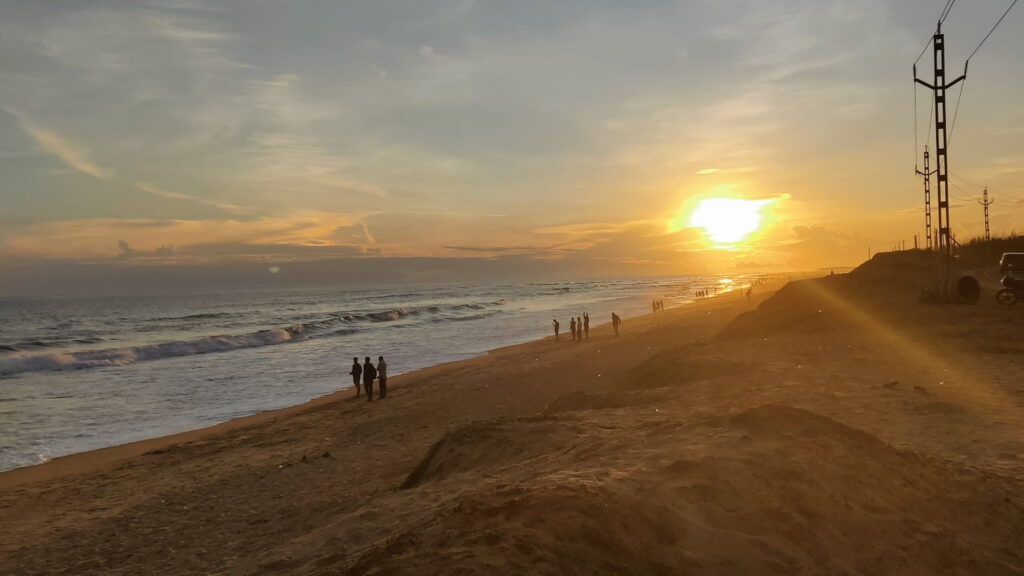 marine_drive_puri_konark_16x9 (1) Sunset view at Marine Drive beach on the Puri to Konark route with waves, golden sky, and people walking along the shoreline.