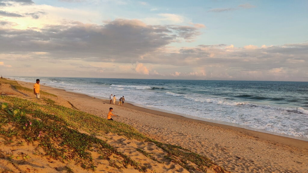 puri-konark-marine-drive-beach-scenery.jpg Beautiful beach scenery at Marine Drive on the Puri to Konark coastal road with golden sand dunes, blue sky, and waves of the Bay of Bengal.